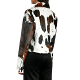 Person wearing a cow print jacket