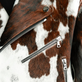 Close-up of a brown and white cowhide leather jacket with zippers.