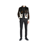 Person wearing a cow print jacket and black jeans