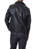 Person wearing a black leather jacket and dark jeans