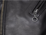 Close-up of a black leather jacket with a zipper and keychain detail.