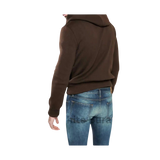 Person wearing a brown hoodie and blue jeans