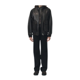 Person wearing a black leather jacket and pants