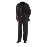 Person wearing a black leather coat over a black outfit