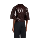 Person wearing a shiny brown jacket and black pants