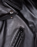 Close-up of a black leather jacket with zipper and button details.