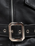 Close-up of a black leather jacket with a silver buckle and zipper.