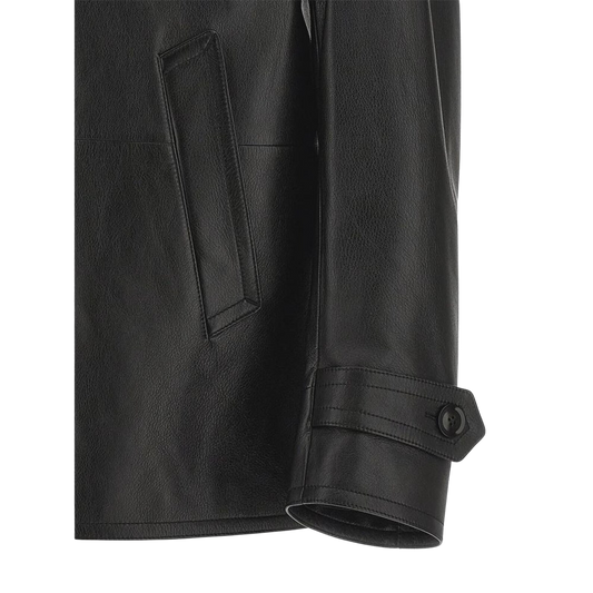 Close-up of a black leather jacket with a pocket and button detail 