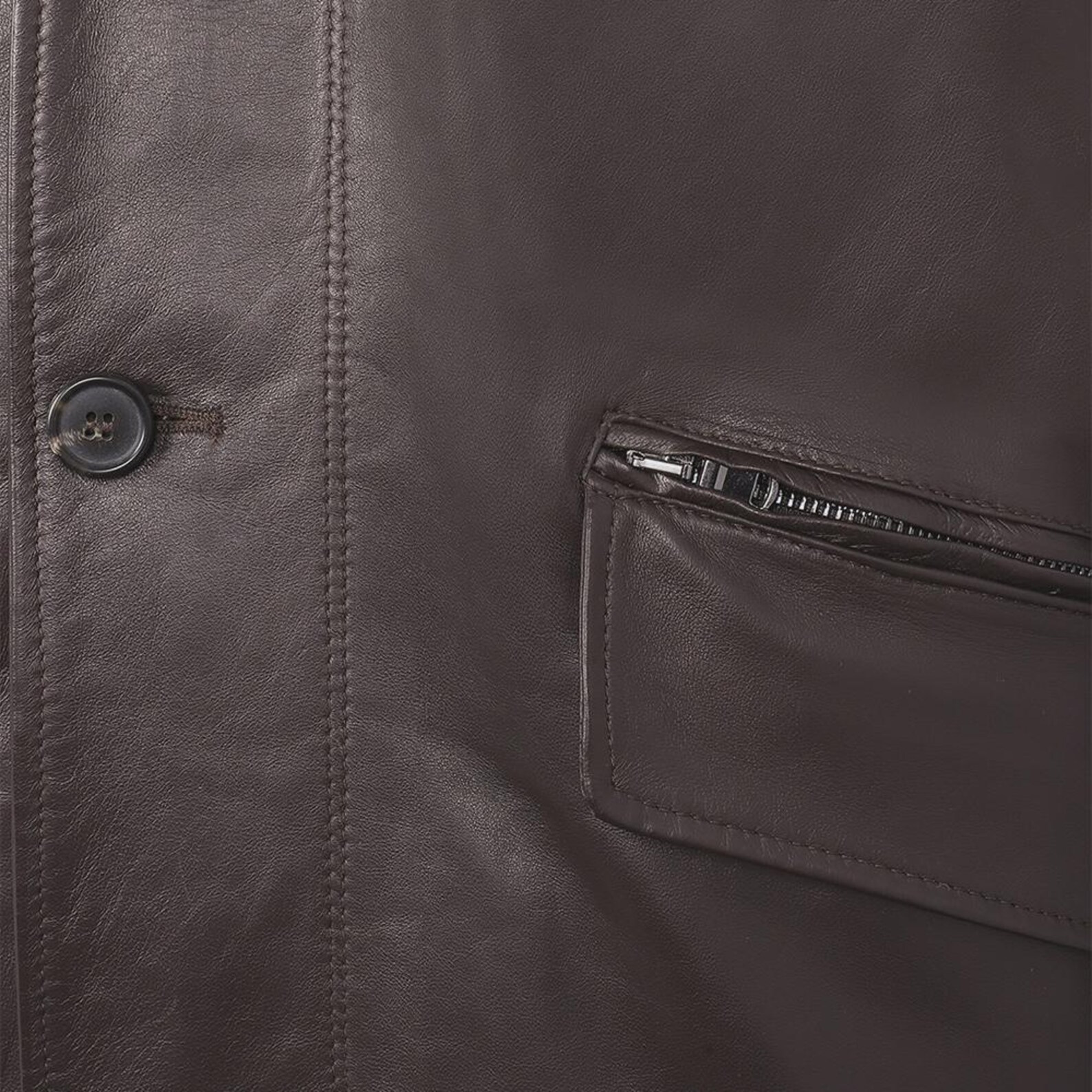 Close-up of a brown leather jacket with a button and zipper pocket.