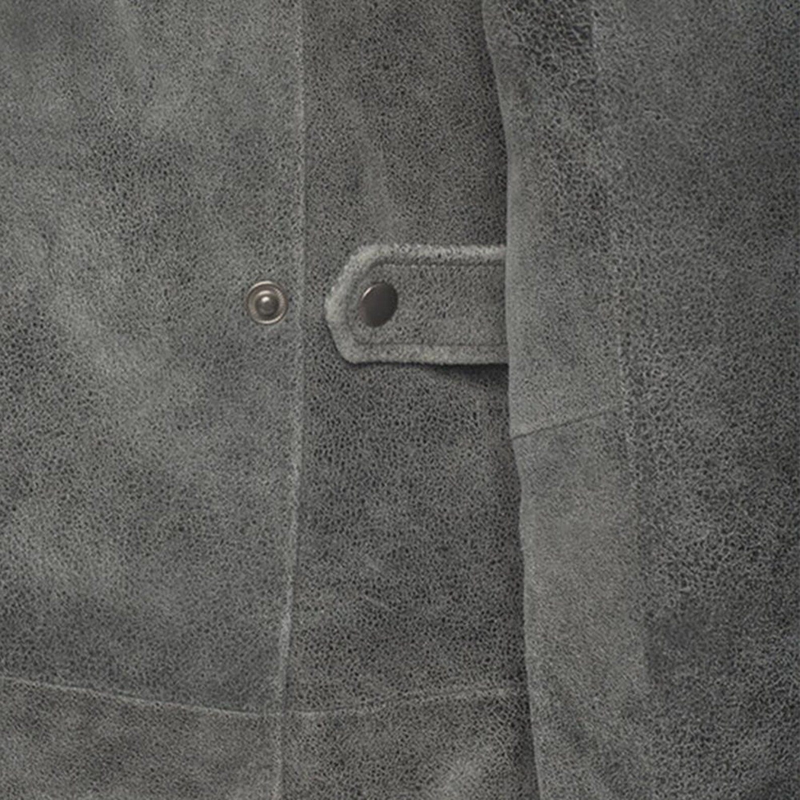 Close-up of a textured gray fabric with a button and stitching detail.