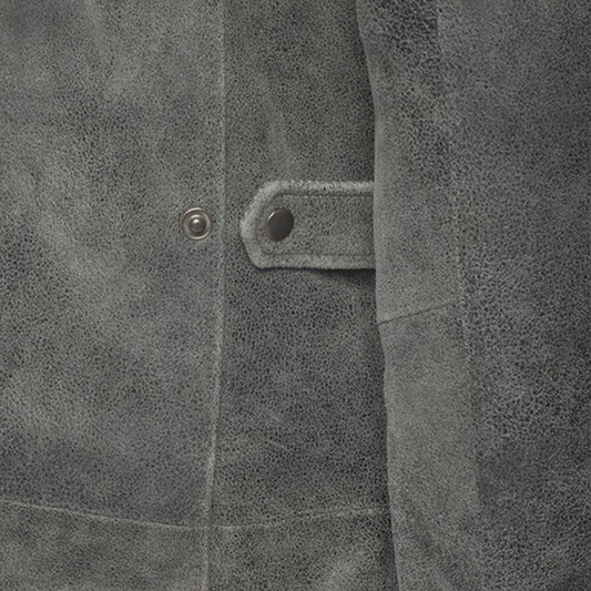 Close-up of a textured gray fabric with a button and stitching detail.