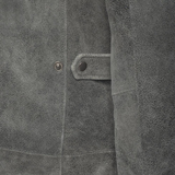 Close-up of a textured gray fabric with a button and stitching detail.
