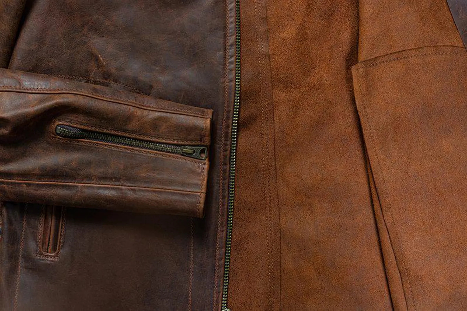 Close-up of a brown leather jacket with a zipper detail