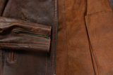Close-up of a brown leather jacket with a zipper detail