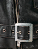 Close-up of a black leather jacket with a silver buckle and zipper.