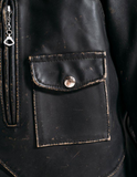 Close-up of a black leather jacket with a buttoned pocket.