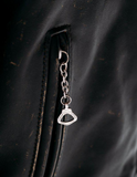 Silver keychain attached to a dark leather surface