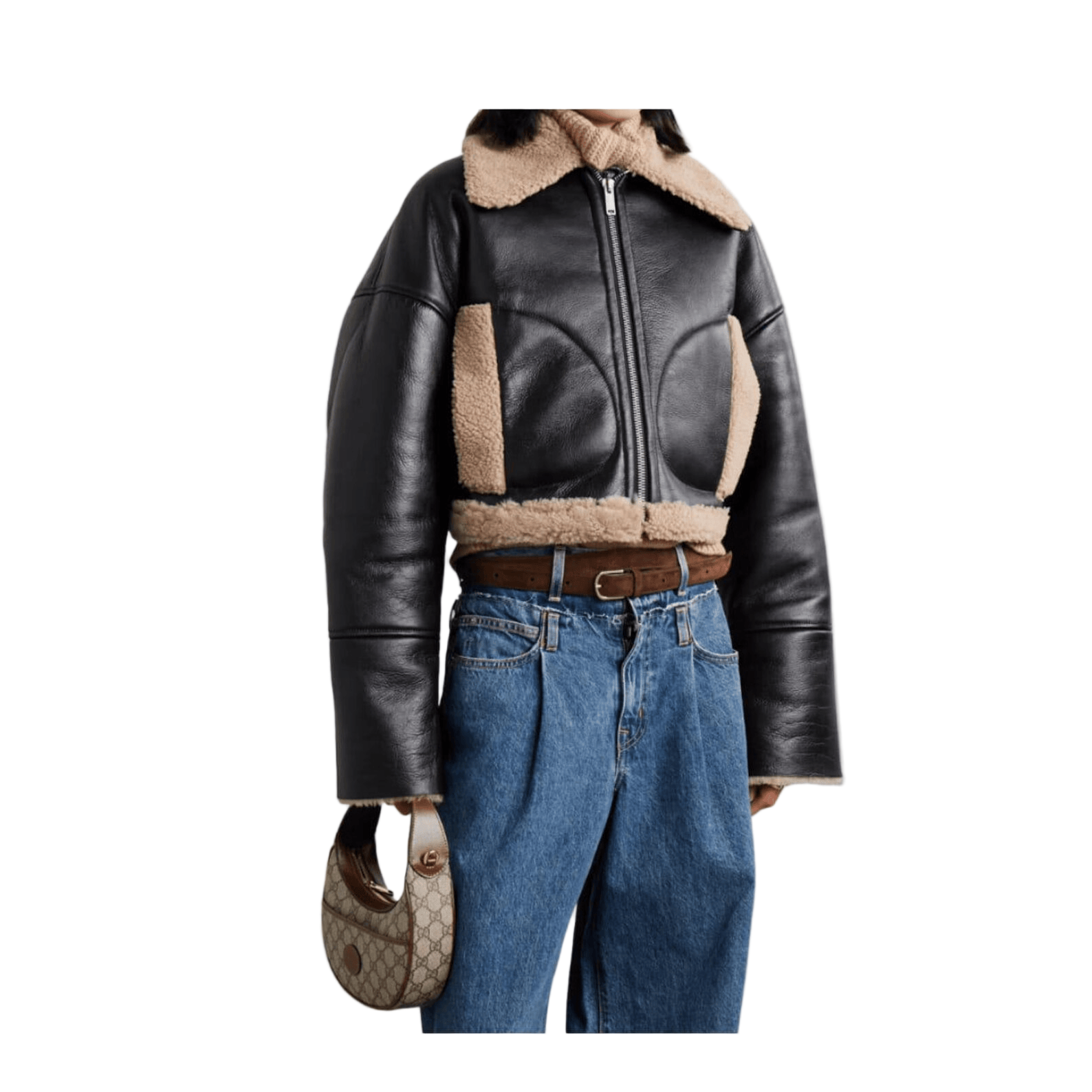 Person wearing a black leather jacket with shearling collar and blue jeans, holding a handbag.