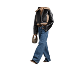 Person wearing a black leather jacket with shearling lining, blue jeans, and brown boots 