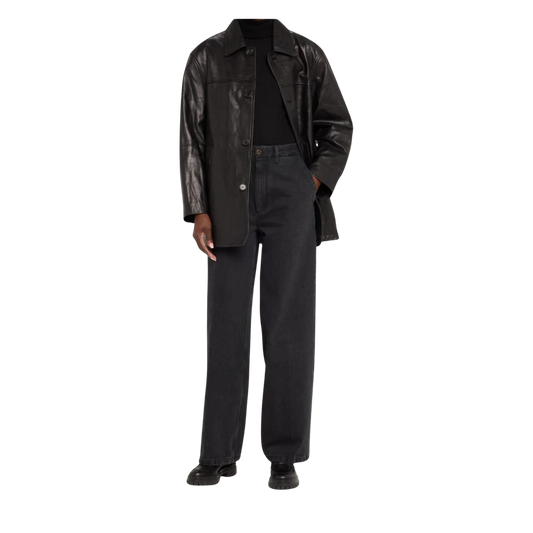 Person wearing a black leather coat over a black outfit 