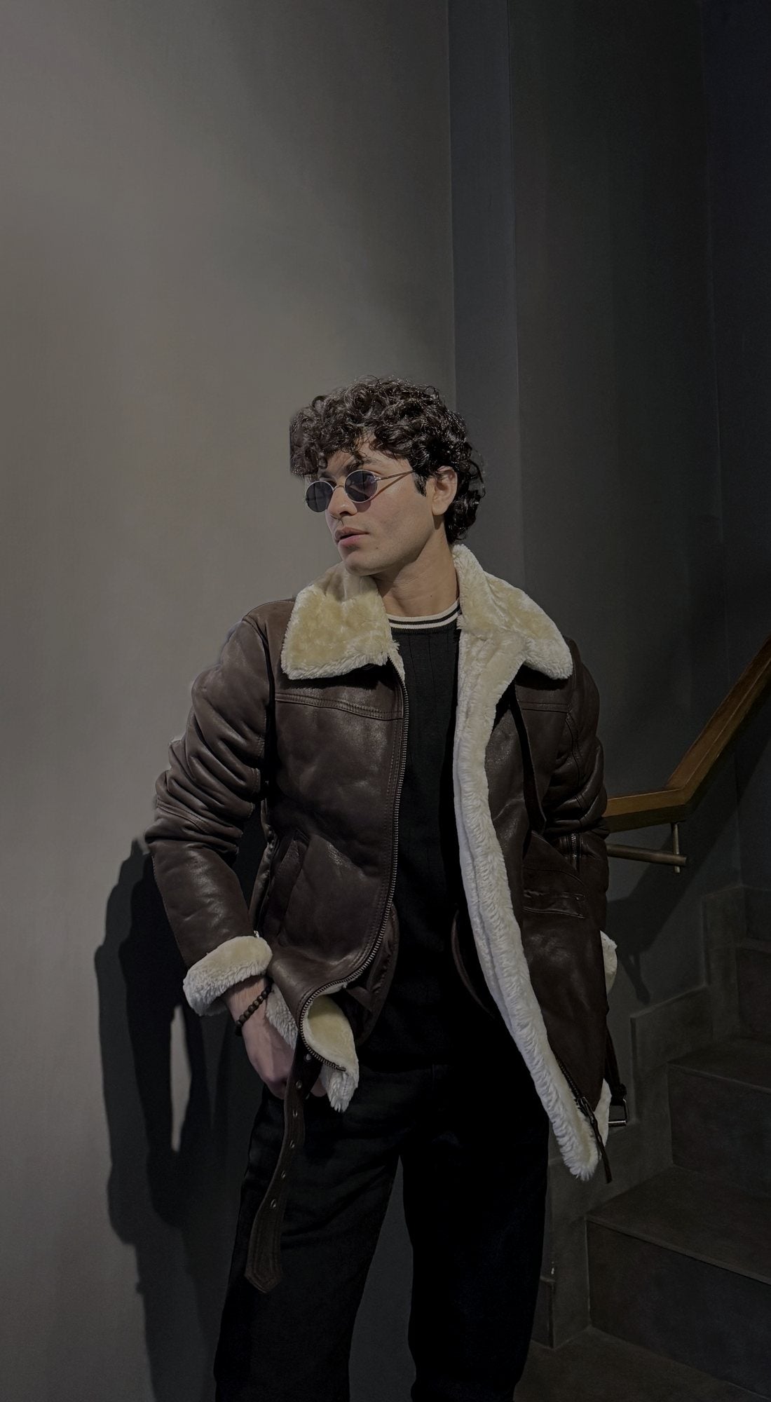 Man wearing a brown leather shearling aviator jacket